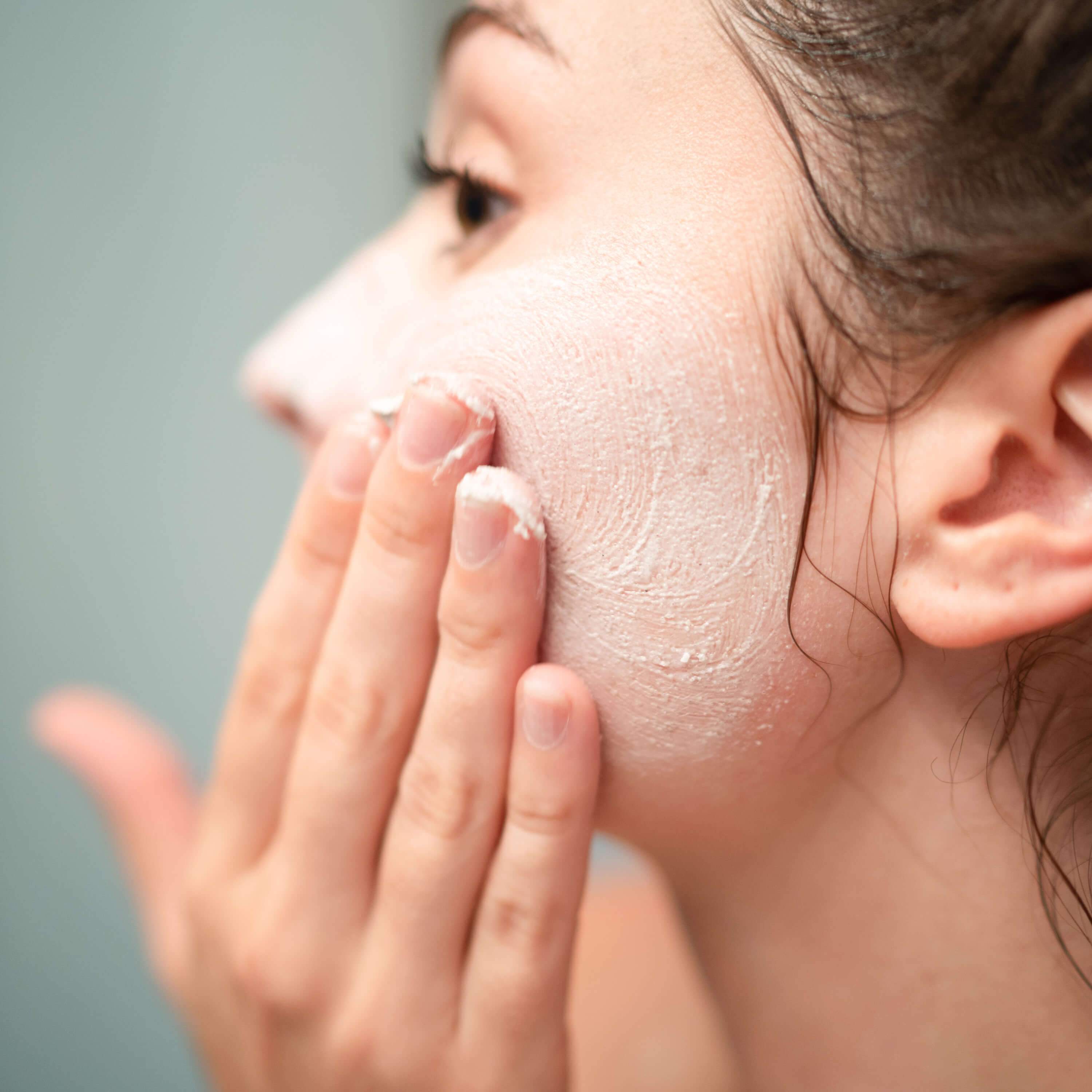Person applying Lemongrass Peppermint Whipped Soap + Scrub on face
